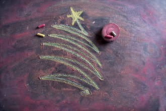 Small stylized christmas tree on blackboard with chalk