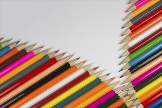 Abstract composition of a set cedar wooden colour pencils against a white background in zipper