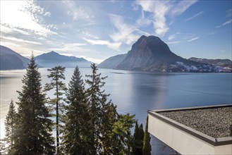 Sunny view of Lake Lugano and nice residential buildings on the shore (roofs of 2 apartment