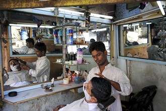 08.12.2011, Mumbai, Maharashtra, India, Asia, A barber shaves a customer in a small men's parlour