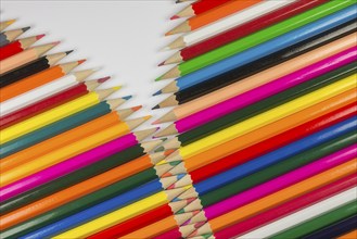 Abstract composition of a set cedar wooden colour pencils against a white background in zipper