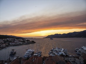 Evening atmosphere at sunset by the sea, view from the bell tower, ships in Korcula harbour,