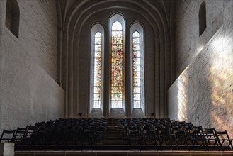 Lubeck, Germany, August 3, 2019: Stained glass window and chairs in the interior of the Cathedral,