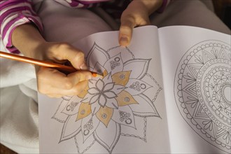 Woman coloring antistress page. Female hand painting mandala. Female painting mandalas to combat