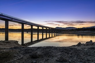 Silhouette Of Bridge Over river at sunset with reflections on water