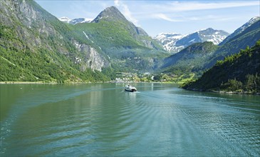 The photo shows a passenger ferry entering the Geirangerfjord