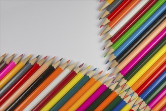 Abstract composition of a set cedar wooden colour pencils against a white background in zipper