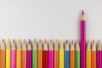 Abstract composition of a set wooden colour pencils against a white background