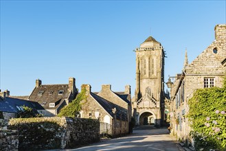 View of the main street of the medieval village of Locronan with the church on background a sunny