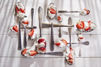 Presentation of the strawberries with cream spoons on various