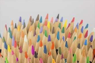 Abstract composition of a set wooden colour pencils against a white background