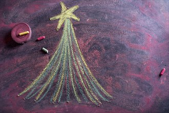 Small stylized christmas tree on blackboard with chalk