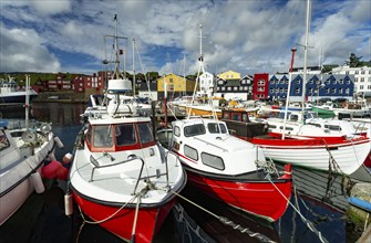 The photo shows various ships in a harbour on the Faroe Islands