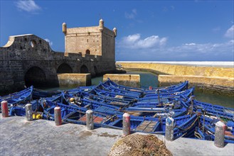 Essaouira, Morocco, 26 March, 2024: the Borj el Barmil watchtower and colourful blue fishing boats