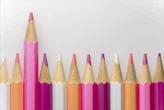 Abstract composition of a set wooden colour pencils against a white background