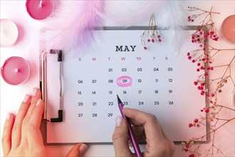 Calendar 9th of May date. Candles flowers feather. Happy Mothers day. Planning holiday. Flat lay.