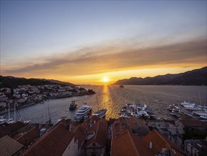 Evening atmosphere at sunset by the sea, view from the bell tower, ships in Korcula harbour,