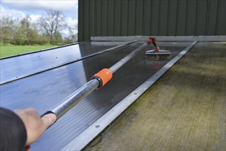 Clean patio roof with telescopic pole and brush