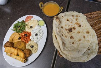 Oriental mixed appetiser plate with halloumi and various pastes and sauces and flatbread