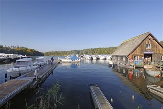 Spacious harbour with boats and jetty, wooden hut on the shore, blue water, fish shop, Eldenburg,