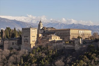 Alhambra on the Sabikah hill, Moorish city castle, Nasrid palaces, behind the snow-covered Sierra