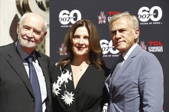 Christoph Waltz supports producers Michael G. Wilson and Barbara Broccoli at their handprints