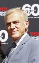 Christoph Waltz supports producers Michael G. Wilson and Barbara Broccoli at their handprints