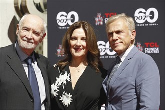 Christoph Waltz supports producers Michael G. Wilson and Barbara Broccoli at their handprints