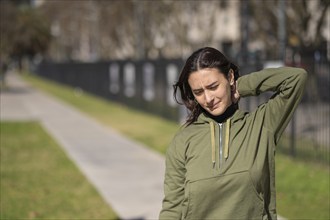 Woman massages her neck. Sportswoman with neck pain massages herself