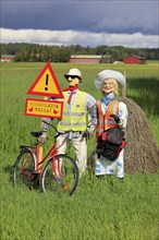 Funny arrangement of an couple with safety vests on alerts motorists of the Hiiden koulu school