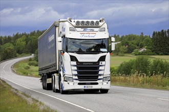 Customised Scania S500 truck of Transport K. Lindholm & Co pulls semi trailer along highway in the