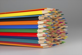 Abstract composition of a set wooden colour pencils against a white background