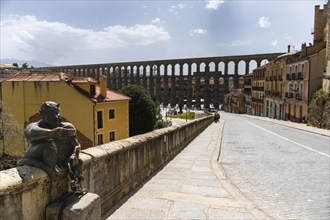 Segovia, Spain, 7 April, 2024: view of the devil statue and the aqueduct of Segovia in the