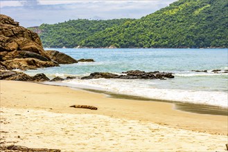 The sea between the beach, rocks and fully preserved rainforest in Trindade, Paraty district in Rio