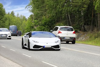 White Lamborghini Huracán AWD 2015 sports car at speed in highway traffic on a day of summer. Salo,