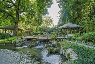 2 wooden gazebos and a small waterfall in the Japanese garden in the botanical garden in Augsburg.