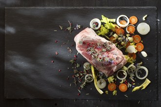 Presentation of a pork shank on stone slate