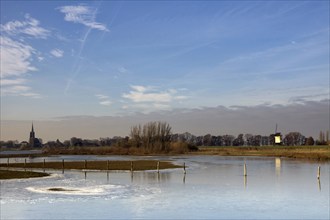 Frozen river foreland from the river Maas near the Dutch village Batenburg with the church tower