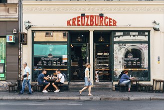 Berlin, Germany, July 29, 2019: Trendy restaurant with tables on sidewalk in Kreuzberg quarter.