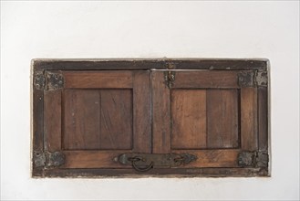 An old wooden shutter in a white wall, Mexico, Central America