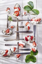 Presentation of the strawberries with cream spoons on various