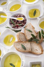 Presentation of wholemeal bread and olives with olive oil