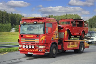 Scania flatbed tow truck of Hinaus Andersson Oy carrying a vintage fire truck. Salo, Finland.