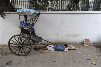 25.02.2011, Kolkata, West Bengal, India, Asia, A rickshaw driver sleeps next to his wooden rickshaw