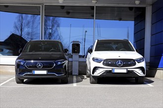 Black Mercedes-Benz EQA 250 battery electric SUV year 2023 and new white Mercedes-Benz 4matic SUV