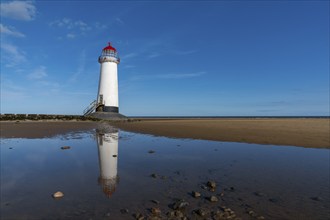 A view of the Point of Ayr Lighthouse and Talacre Beach in northern Wales with reflections in a