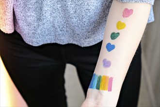 Rainbow LGBTQ flag painted on hand. Support for lgbt community. Honour of pride month. Connecting