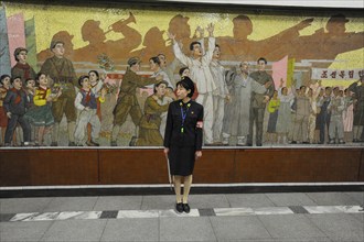 09.08.2012, Pyongyang, North Korea, Asia, A platform supervisor stands in front of a huge mosaic