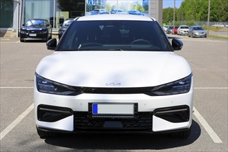 White Kia EV6 fully electric crossover car parked at the new car dealership. Front view. Salo,