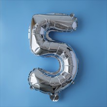 5 five metallic balloon isolated on blue background. Greeting card silver foil balloon number Happy